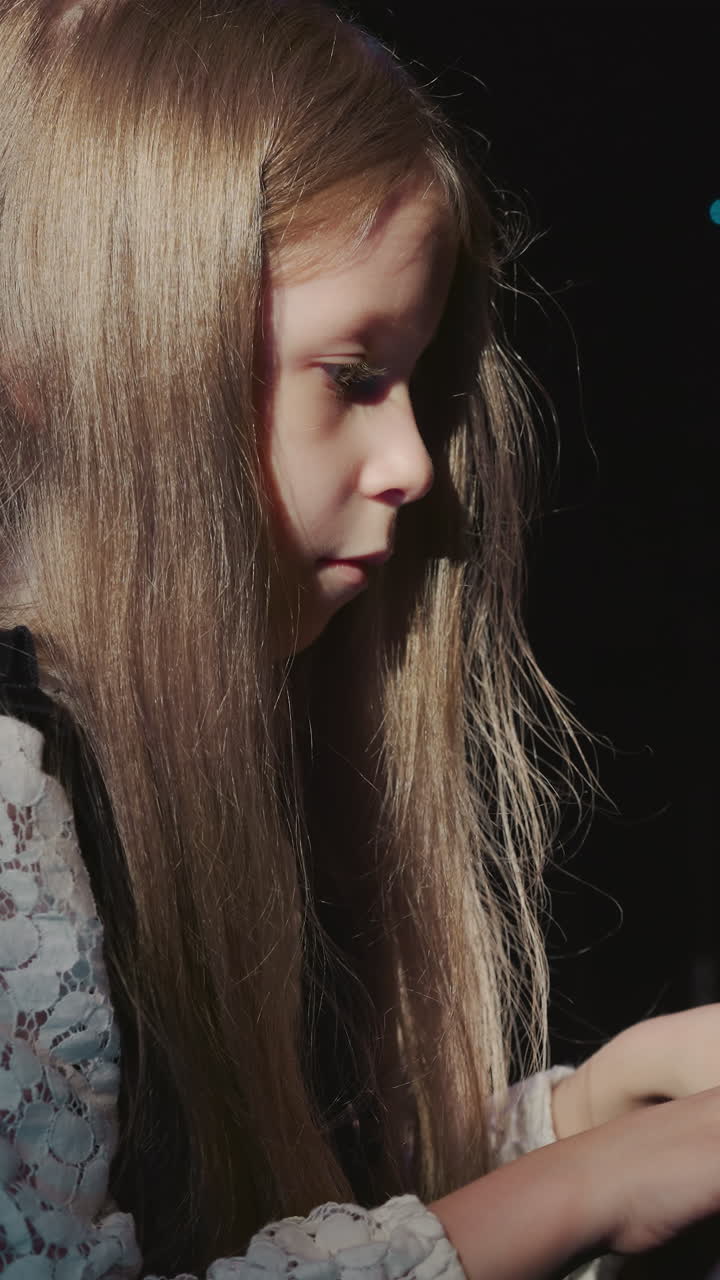 niño toca el sintetizador vista lateral. bonita estudiante junior opera piano digital en la academia de música durante la lección. momento cautivador en el proceso artístico