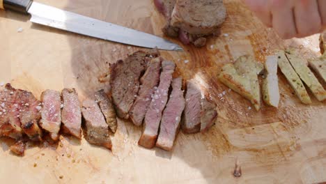 salt being sprinkeld on top of different kinds of meat