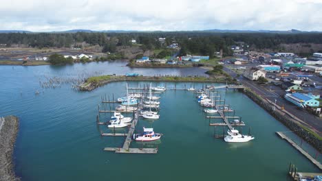 Beautiful-4K-aerial-drone-shot-peaking-over-Old-Town-Bandon-and-docked-boats-in-Southern-Oregon