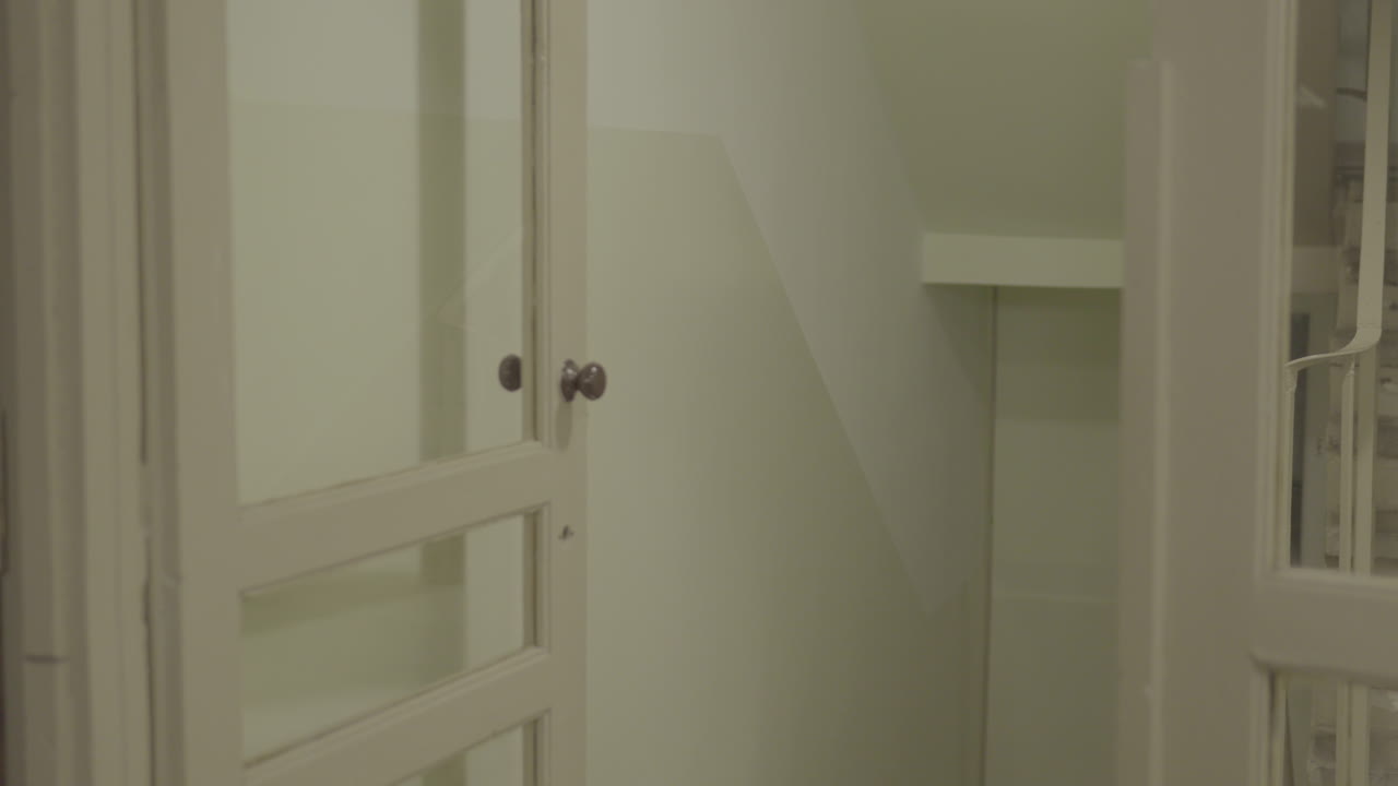 Classica porta in legno bianca parzialmente aperta su un corridoio