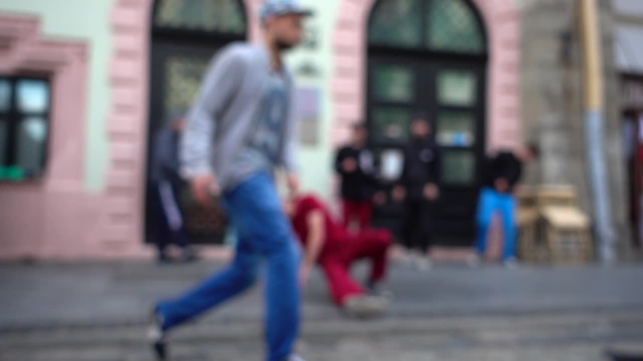 Rapazes desconhecidos dançam break na rua da cidade. Em câmera lenta. Desfocado