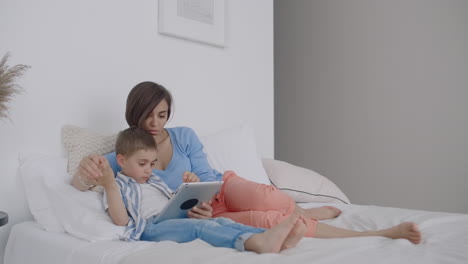familia feliz madre y hijo con tableta por la noche. familia feliz madre e hijo con tabletas por la noche antes de acostarse