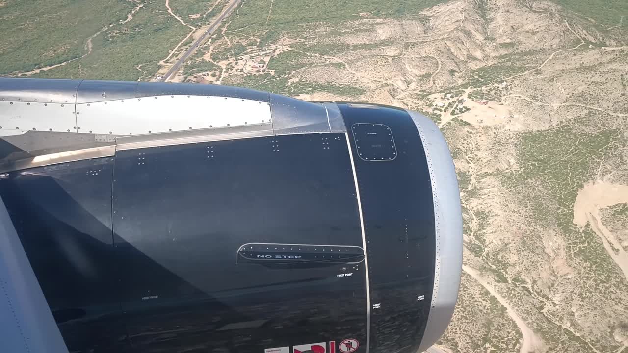 disparo de mano mirando por una ventana de un avión mirando hacia el motor y el paisaje estéril