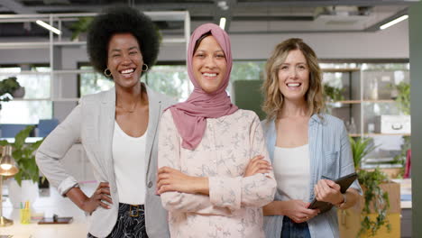 Portrait-of-happy-diverse-creative-female-colleagues-with-tablet-in-office,-slow-motion