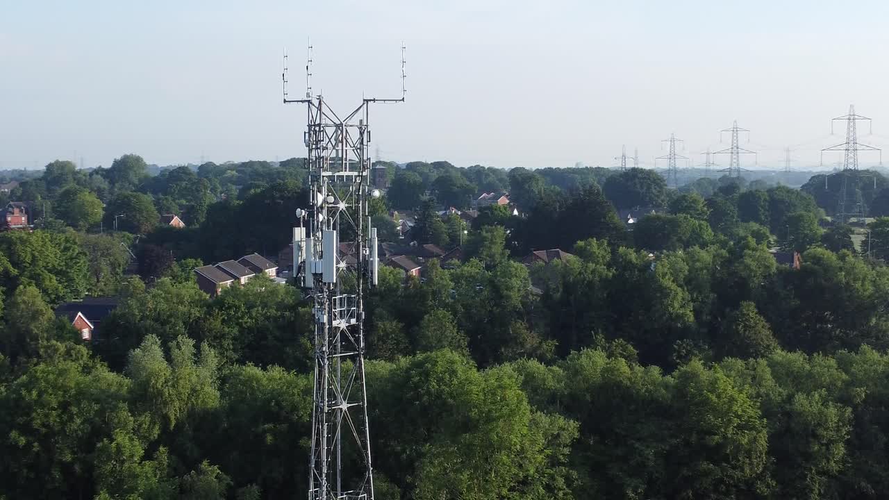 antena de torre de radiodifusión 5g en la campiña británica con vehículos que viajan por la carretera vista aérea de la órbita izquierda del fondo