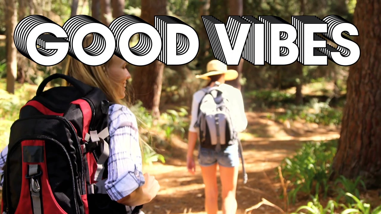 Femme en tête marchant devant, guidant une amie ajustant son sac à dos, souriant sous le titre GOOD VIBES, voyage de loisirs.