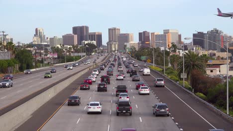 Traffic-moves-along-a-California-freeway-near-San-Diego-with-airplanes-landing-overhead