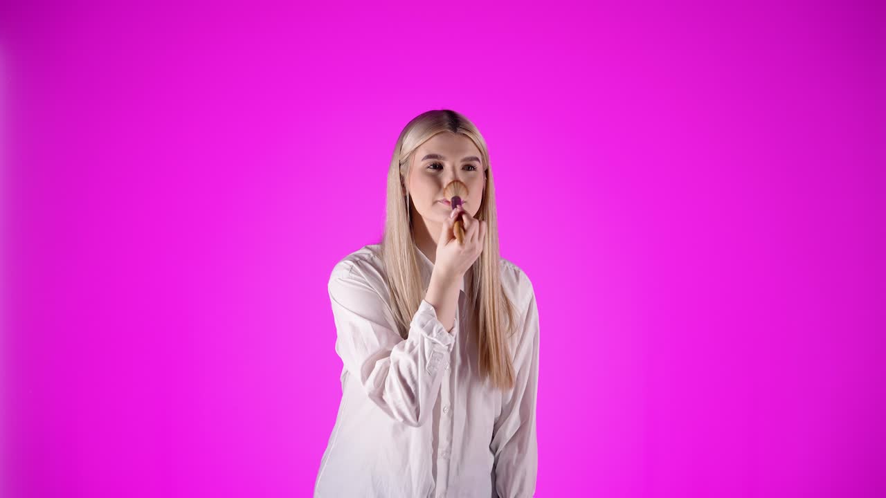 mujer europea de estilo, se prepara, la aplicación de maquillaje aislado fondo violeta