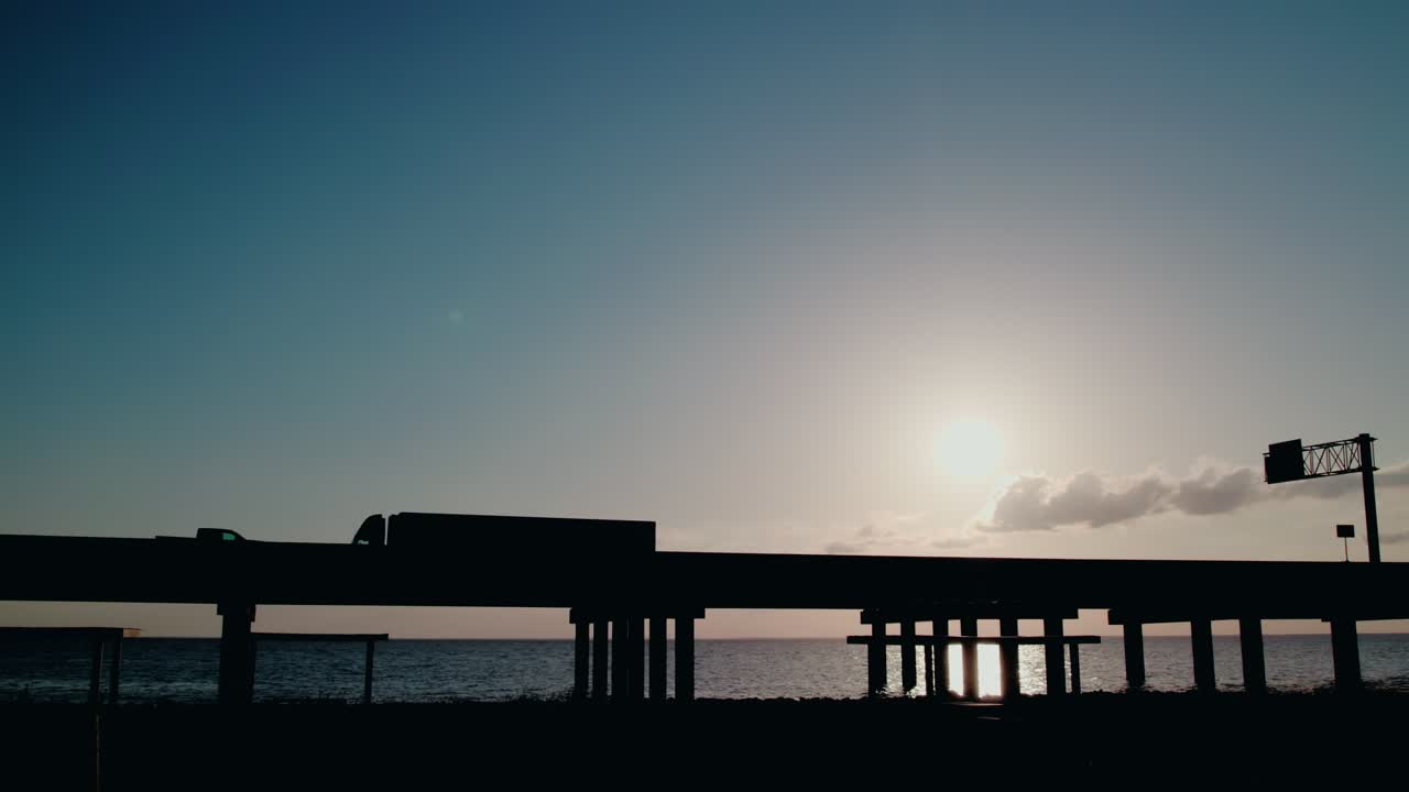 A silhouetted truck crosses a bridge at dawn—an ideal reference frame for AV systems, mobility tracking, and autonomous freight design. Luisiana state