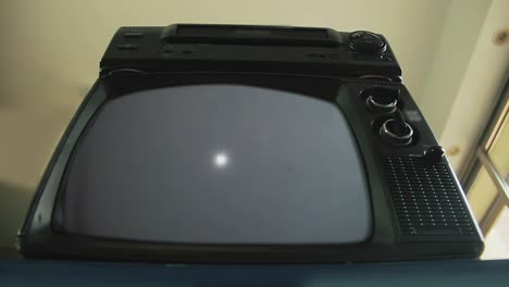 man hand inserting vhs cassette in old video recorder, a retro television turns on green screen. low angle view. 4k resolution.