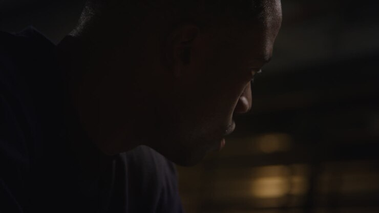Close Up Of Unhappy And Depressed Young Man Sitting On Sofa At Home At Night Closing Eyes And Putting Head In Hands 2