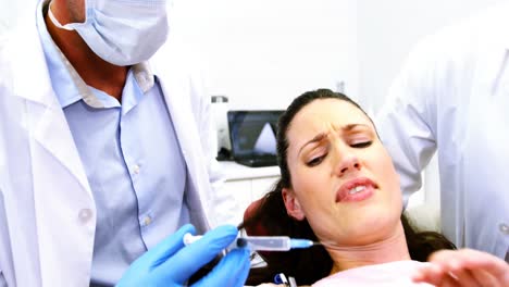 mujer deteniendo al dentista para examinarla en la clínica