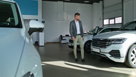 hombre mirando coches en un concesionario de coches