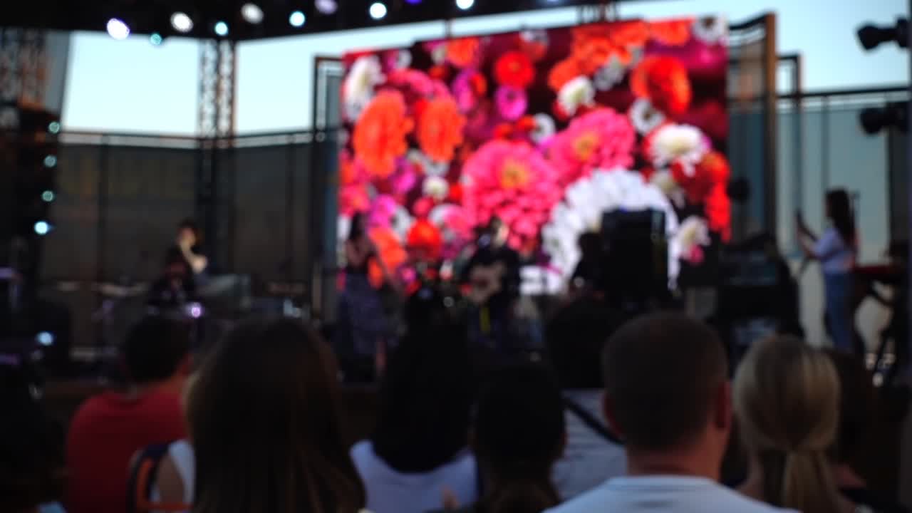 Concerto no palco. Multidão de pessoas e músicos no palco. Desfocado