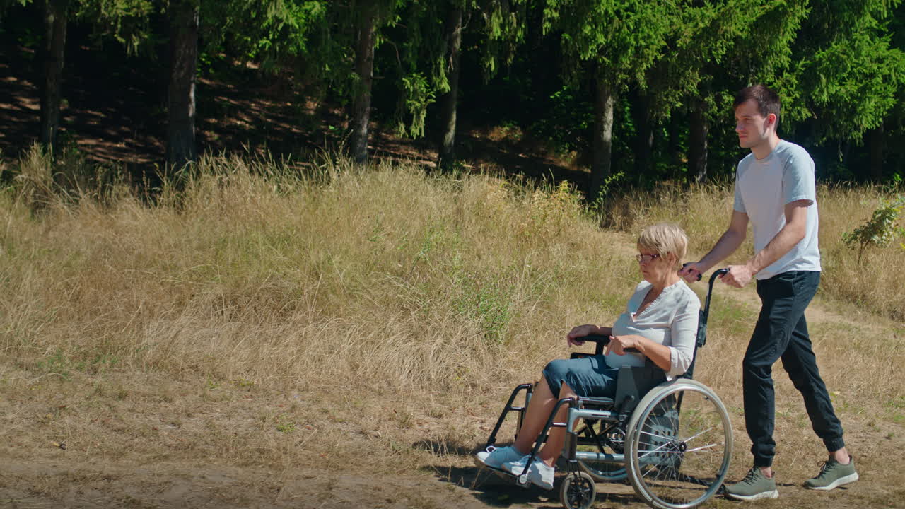 hombre empujando a una mujer en silla de ruedas en el parque