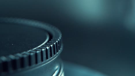 A-macro-close-up-shot-of-a-black-plastic-wheel-on-a-360-rotating-stand,-cinematic-studio-lighting,-120-fps,-Slow-motion,-Full-HD