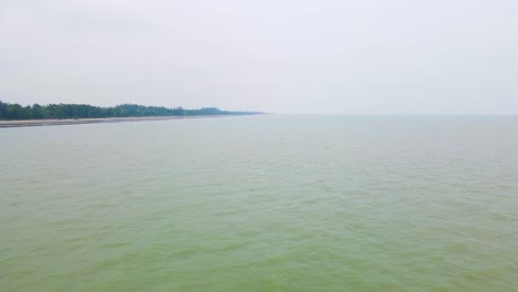 Vuelo-Aéreo-Bajo-Sobre-Las-Aguas-Verdosas-Y-Calientes-De-La-Costa-De-La-Playa-Del-Mar-De-Kuakata,-Bangladesh,-Bahía-De-Bengala,-Océano-Índico