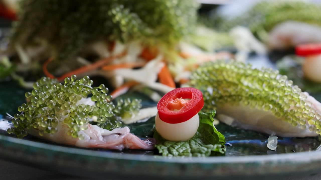 다채로운 태국 해산물 요리의 자세한 클로즈업으로 새우, 바다 포도, 리 조각을 특징으로하며, 활기찬 질감과 신선한 재료를 보여줍니다.