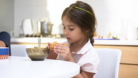 islamic children having breakfast in the kitchen.