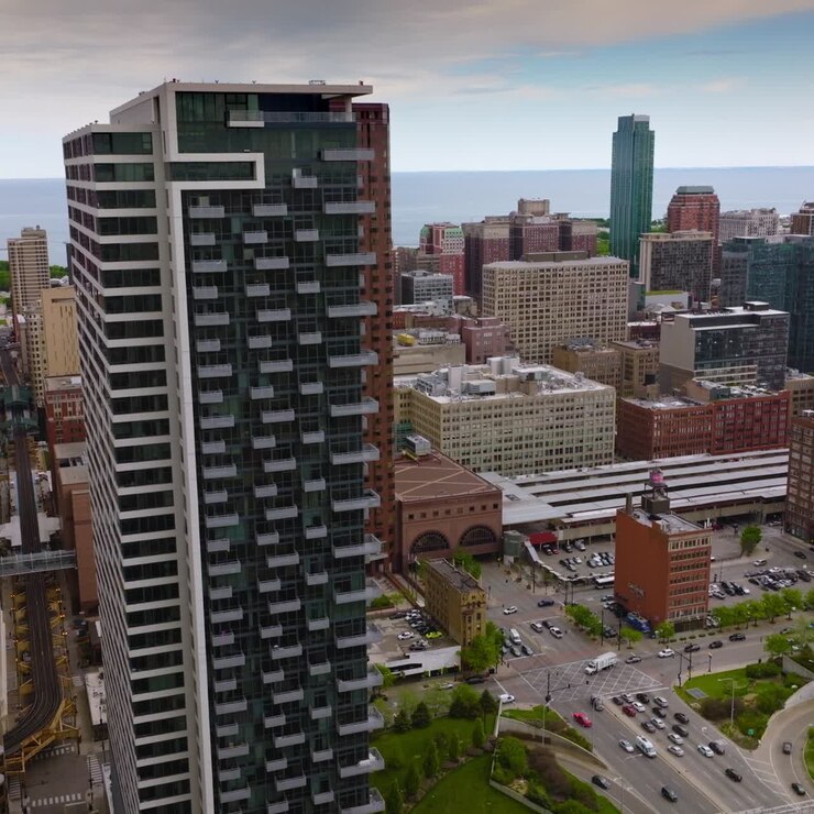Estrada movimentada em meio à bela arquitetura de Chicago. Ferrovia do metrô entre os edifícios. <1>Filmagem</1> de drone descendo