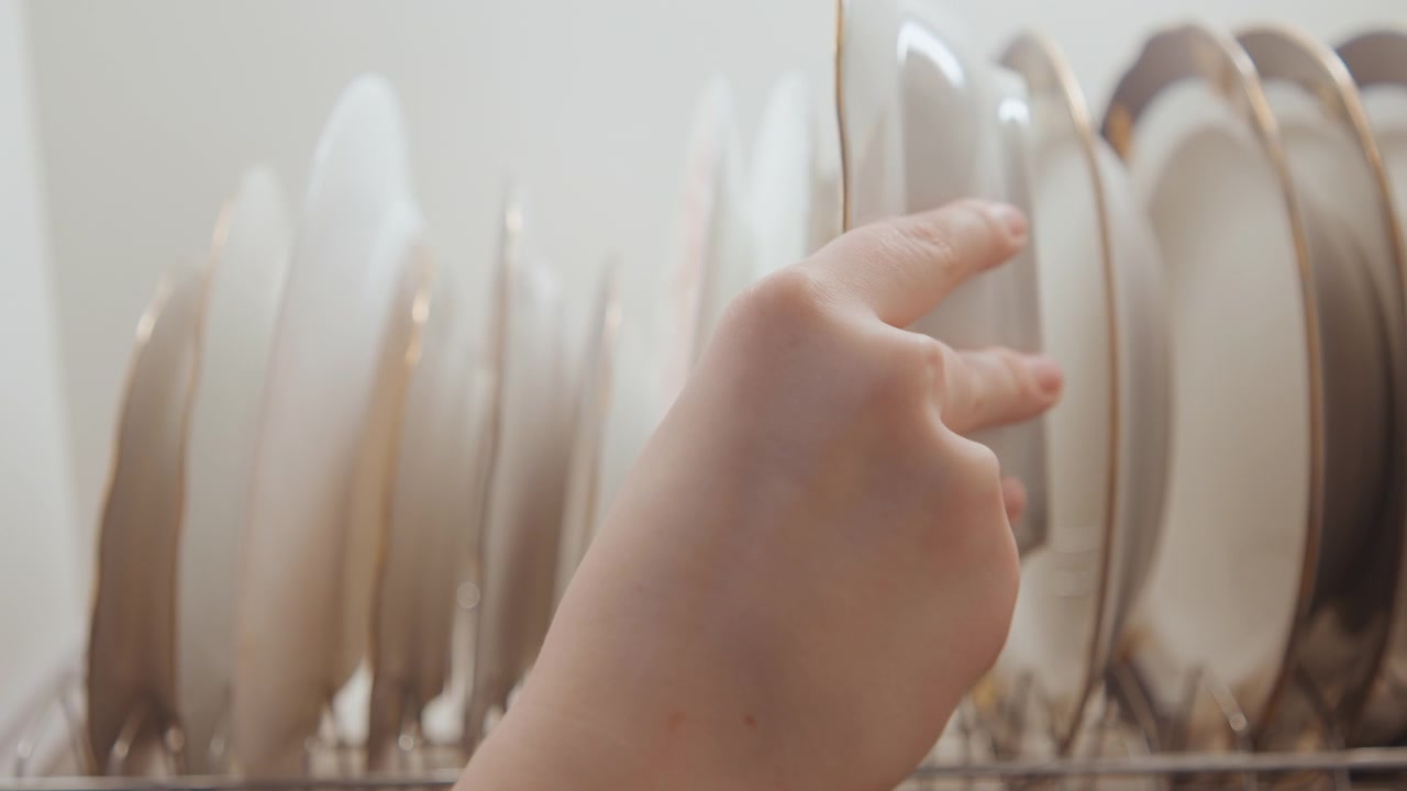 Drying and organizing dinnerware for peace. Neatly placing and drying porcelain dishes after cooking. Meticulously arranging and drying fine porcelain plates as part of calming routine