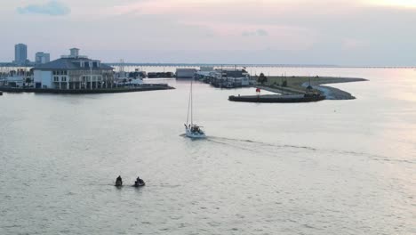 people in boats and jetskis enjoying calm riverside scenery in louisiana usa - aerial shot