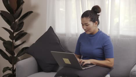 new normal businesswoman work from home by laptop sitting on the sofa happily