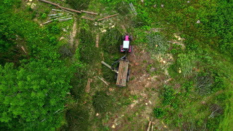 Log-loading-tractor-stacking-timber---straight-down-aerial-view