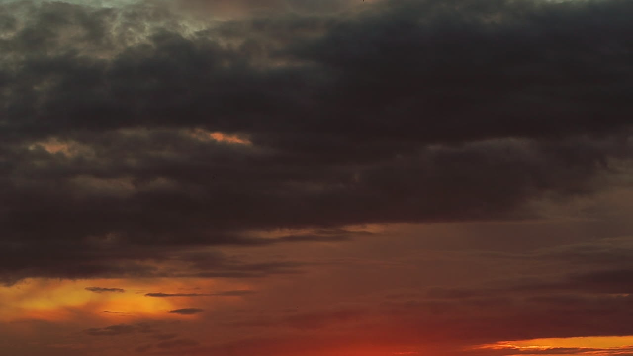하늘에서 부드럽게 움직이는 구름의 아름다운 전망, 구름은 주황색과 푸르스름한 색을 어두운 색으로 만듭니다.