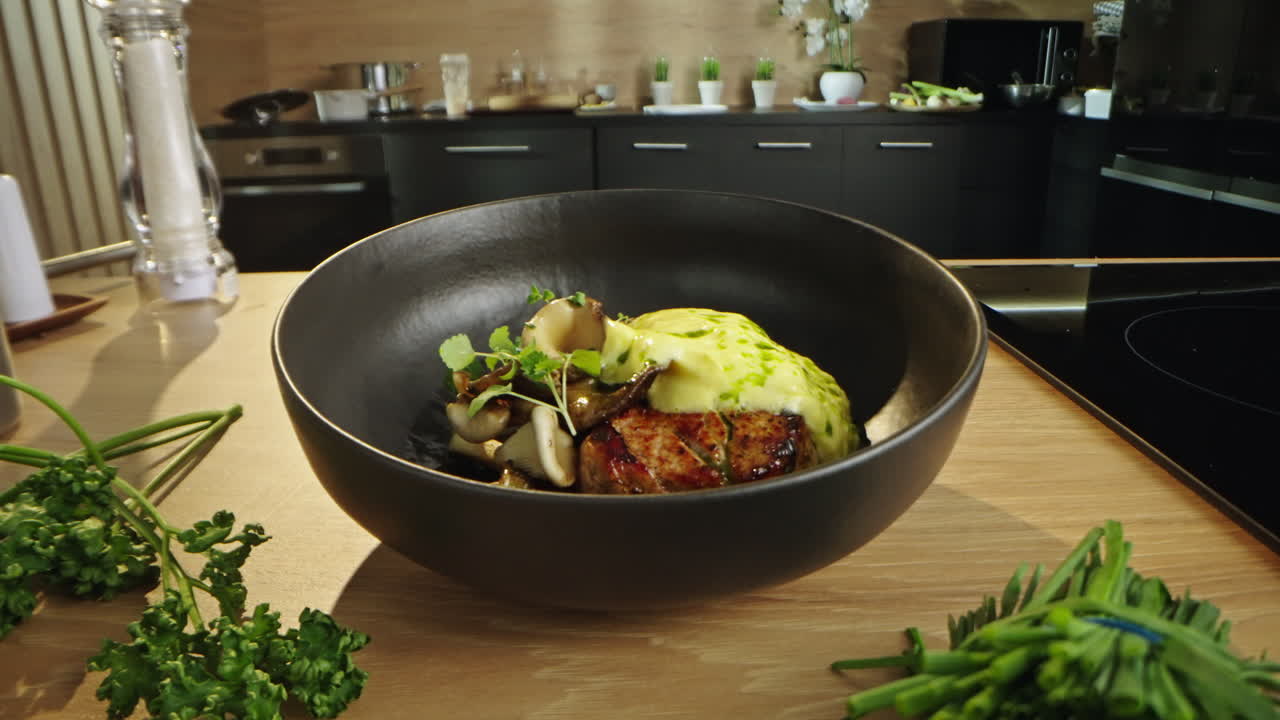 Food photography of a pork tenderloin with mushrooms and sauce in a black bowl