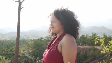 Beautiful-black-girl-with-afro-smiling-on-top-of-a-canyon