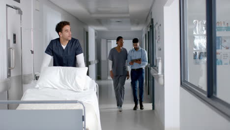 diverse male and female doctors walking in hospital corridor, slow motion