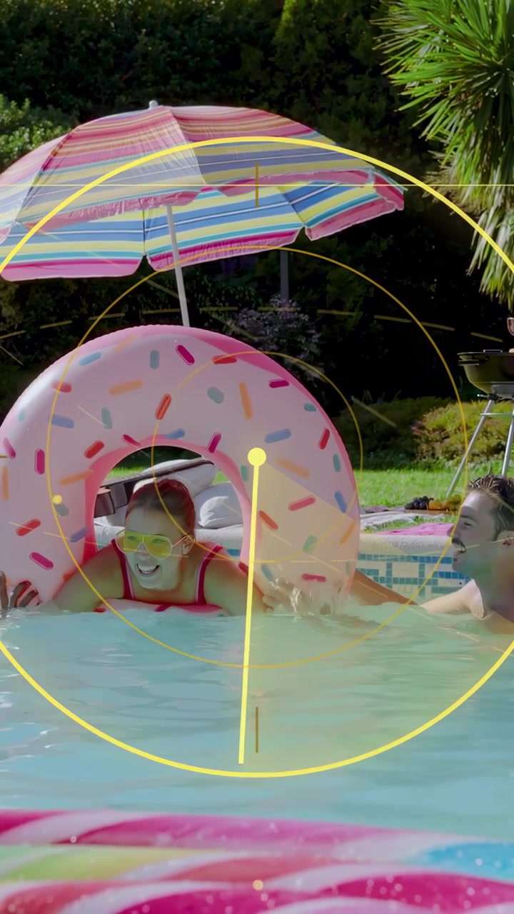 Vertical video: Woman in pink donut moving into pool as friend reaches, HUD sweeping aiding ads