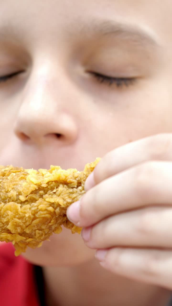 Young boy enjoying crispy fried chicken with eyes closed, savoring the flavors and textures, capturing the joy of eating comfort food in a casual setting