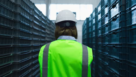 Uniformed-woman-storehouse-worker-examining-supply-boxes-checking-package