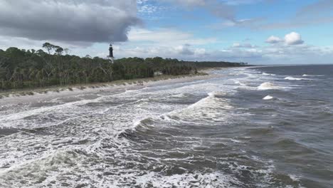 aerial over waves pushing into the hunting island lighthouse