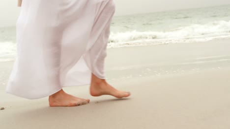 Low-section-of-woman-walking-barefoot-on-the-beach-4k