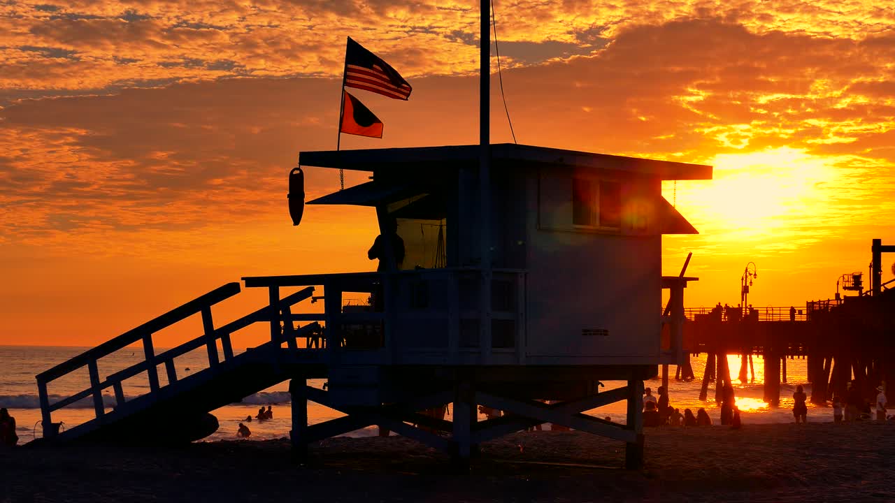 해변 에서 해가 지는 것 과 함께 구명병 들 이 서 있는 것