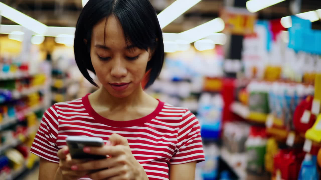 Woman Using Smartphone in a Supermarket