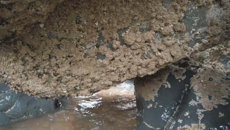 closeup of large rocks by the sea with water splashing against them
