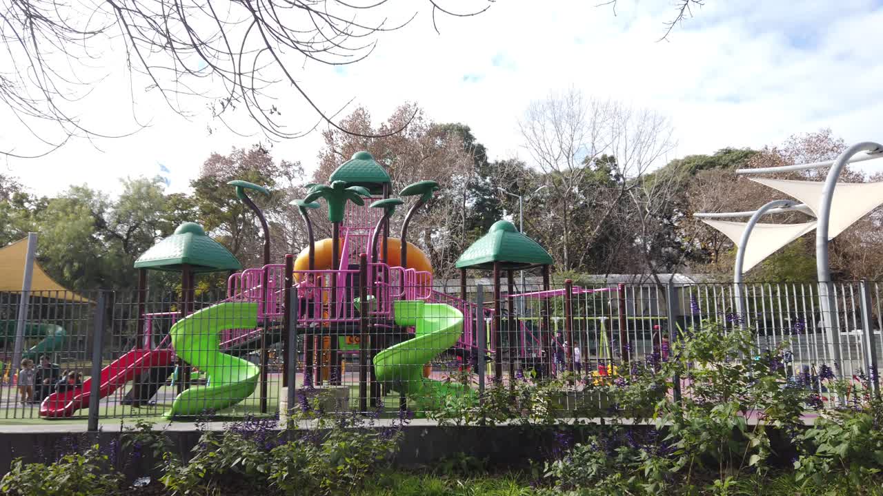 Colorful Playground with Slides and Shade Structures in a Park