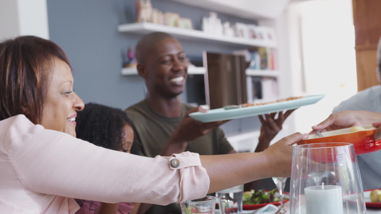 familia de varias generaciones sentada alrededor de la mesa en casa disfrutando de la comida juntos