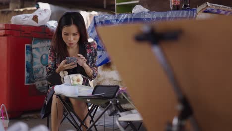 woman using her mobile phone at an outdoor market stall