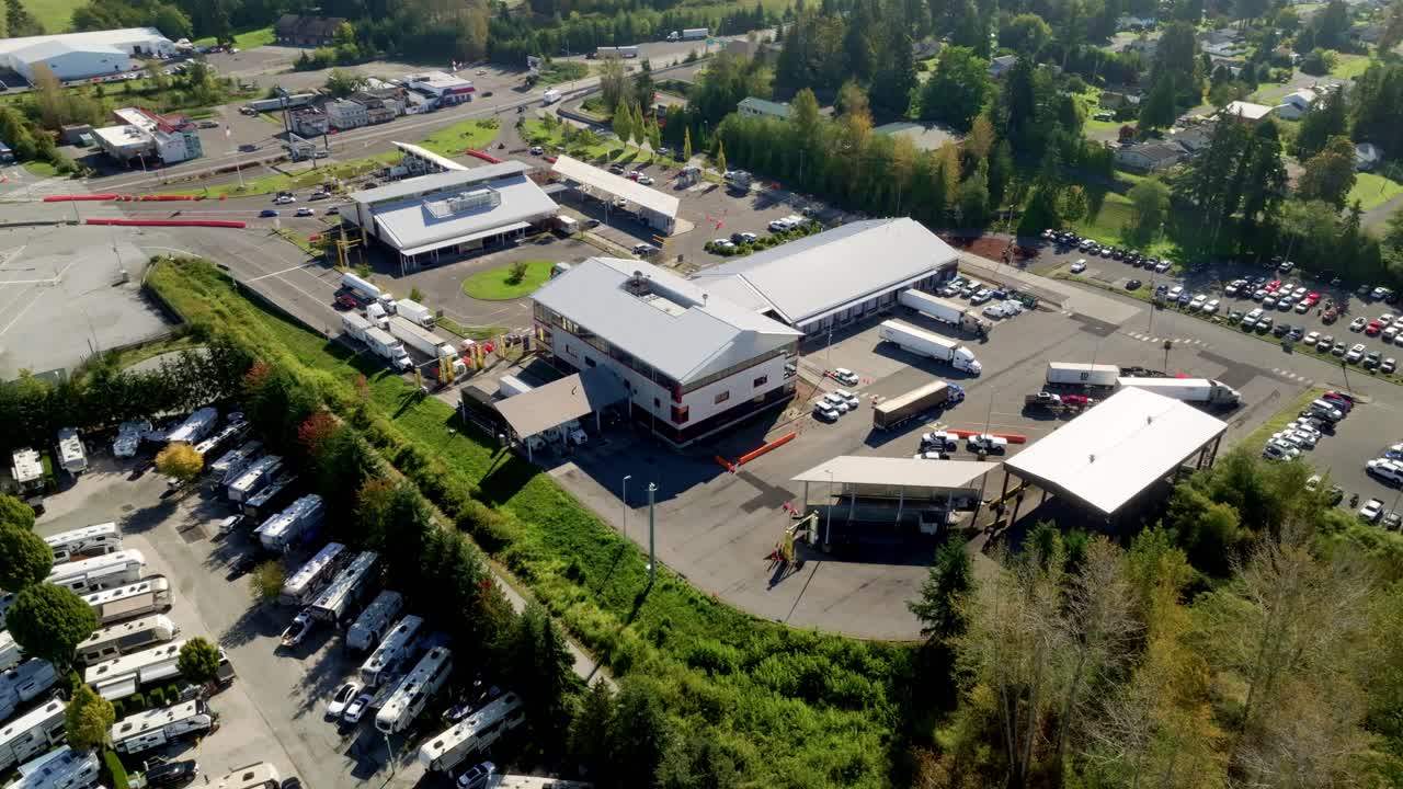 Cars and Trucks Move Through Multiple Checkpoint Lanes at the Busy Border Crossing Between South Surrey, BC, and Blaine, WA - Aerial Drone Shot