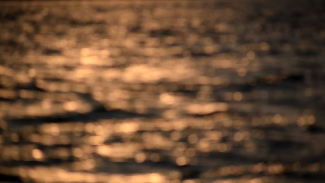 Waves passing by at dawn with beautiful bokeh balls in Desenzano, Garda Lake, North Italy