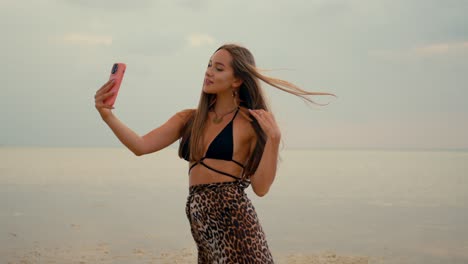 una mujer tomando una selfie en la playa.