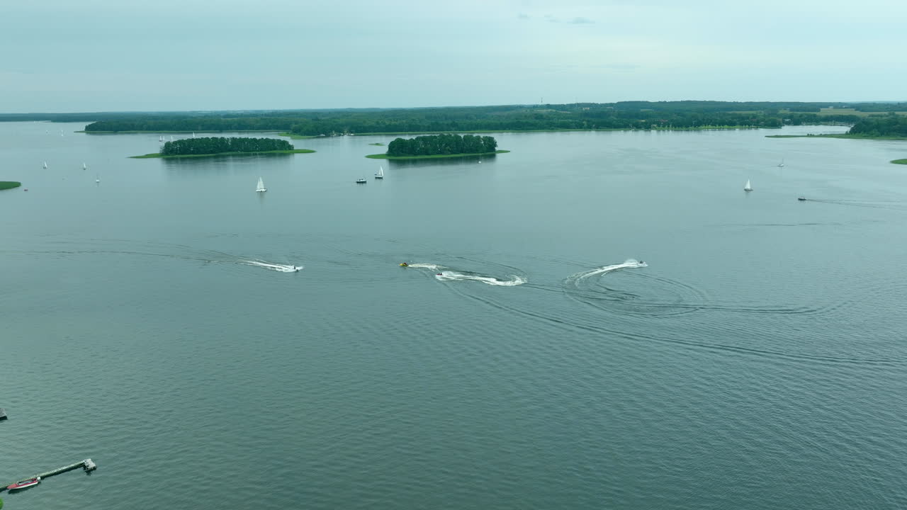 폴란드 시메니에 있는 제지오라크 호수 (jeziorak lake) 의 공중 풍경, 스피드보트 (speedboats) 가 물 위에 을 만들고 멀리서 볼 수 있는 작은 섬들