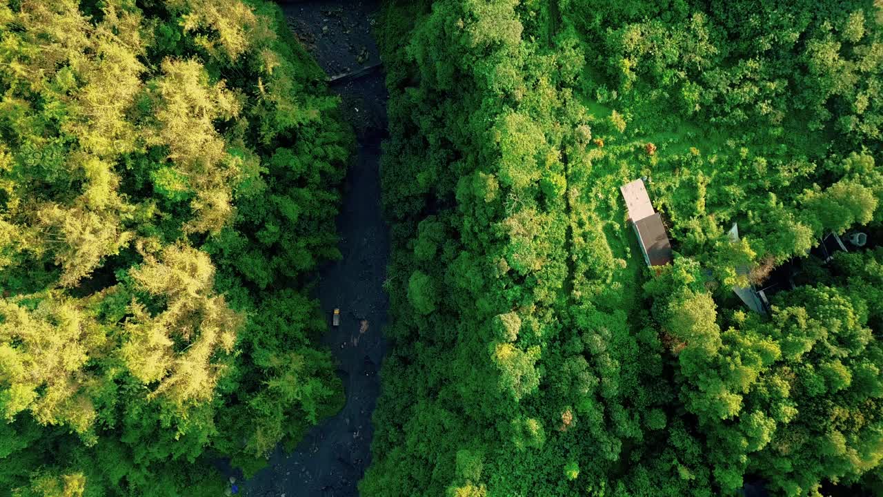 건조하고 큰 강의 바닥에서 모래를 줍는 트럭의 오버헤드 드론 샷