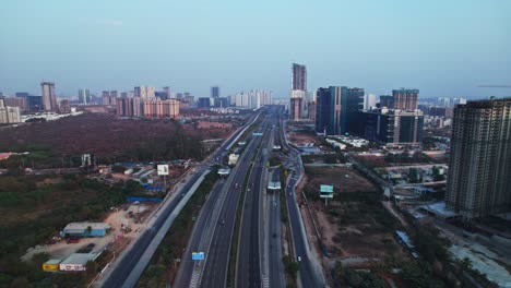nehru outer ring road with under construction building and trees at financial district, nanakramguda, hyderabad, telangana, india. day time, push in, drone shot, 4k.