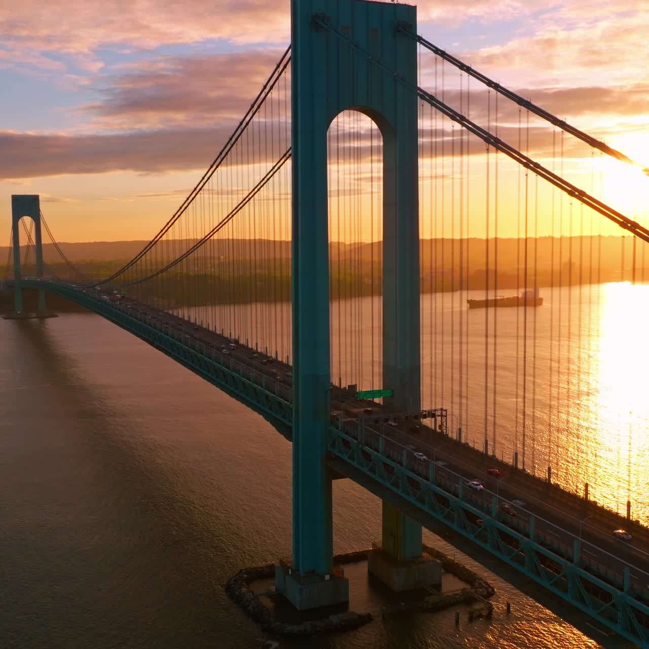 Splendid view of Whitestone bridge over the East River. Fantastic sight of the bridge at the backdrop of setting sun and pink clouds